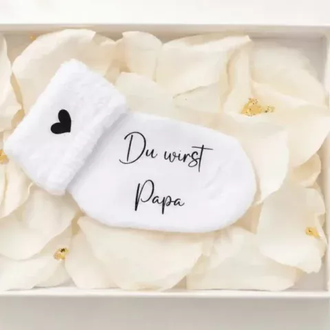 Personalisierte Schwangerschaftsverkündungssocke in eleganter Geschenkbox mit Rosenblättern und Blattgold – liebevolles und einzigartiges Babyankündigungs-Geschenk