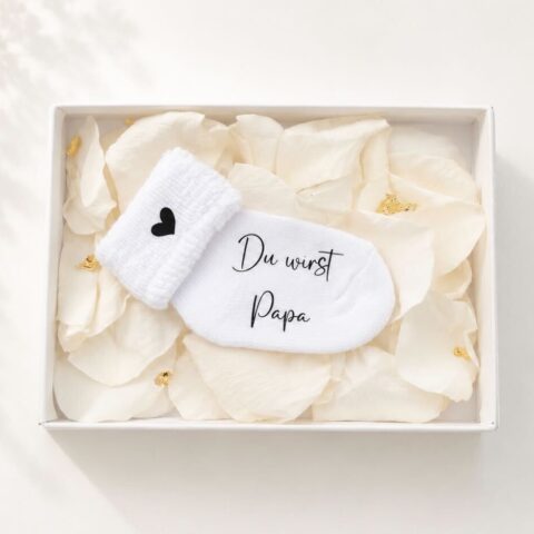 Personalisierte Schwangerschaftsverkündungssocke in eleganter Geschenkbox mit Rosenblättern und Blattgold – liebevolles und einzigartiges Babyankündigungs-Geschenk