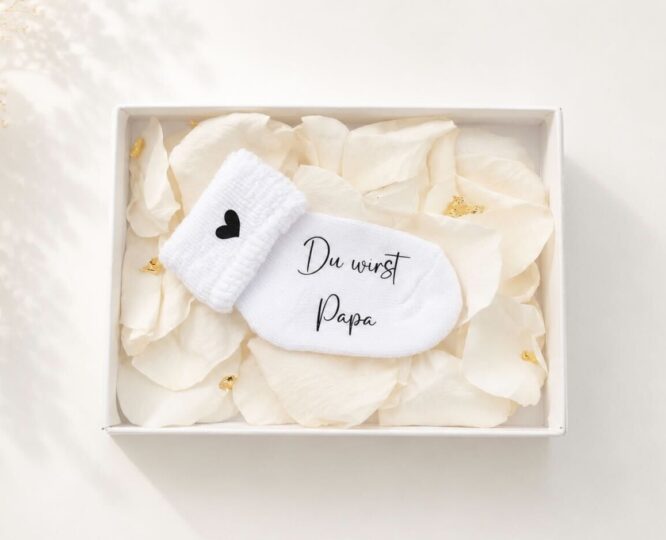 Personalisierte Schwangerschaftsverkündungssocke in eleganter Geschenkbox mit Rosenblättern und Blattgold – liebevolles und einzigartiges Babyankündigungs-Geschenk