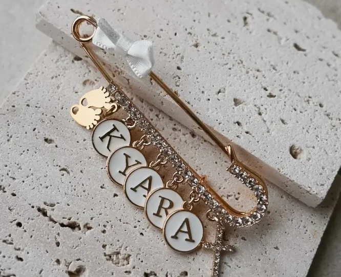 Personalisierte Baby-Anstecknadel in Silber oder Gold mit Schleifenanhänger und Namensgravur – Schutzsymbol für Neugeborene