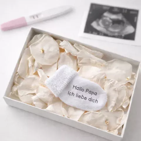 Personalisierte Schwangerschaftsverkündungssocke in eleganter Geschenkbox mit Rosenblättern und Blattgold – liebevolles und einzigartiges Babyankündigungs-Geschenk
