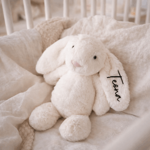 White plush bunny with printed name on the ear, cuddly soft toy as a personalised gift for birth or christening