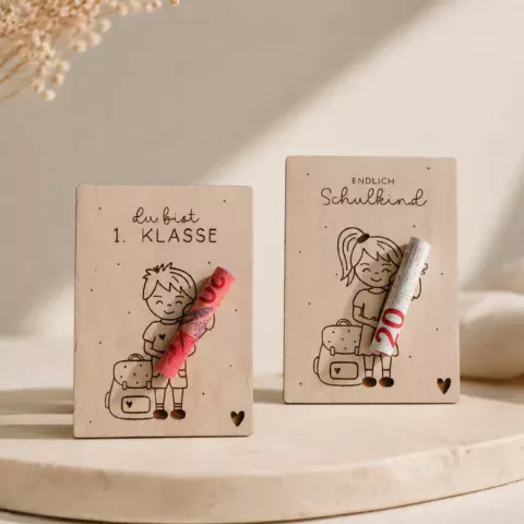 Geldgeschenk Einschulung Holz mit Mädchen- und Jungen-Motiv. Die beiden Holzanhänger bieten Platz für einen Geldschein und sind eine kreative Geschenkidee zur Einschulung.